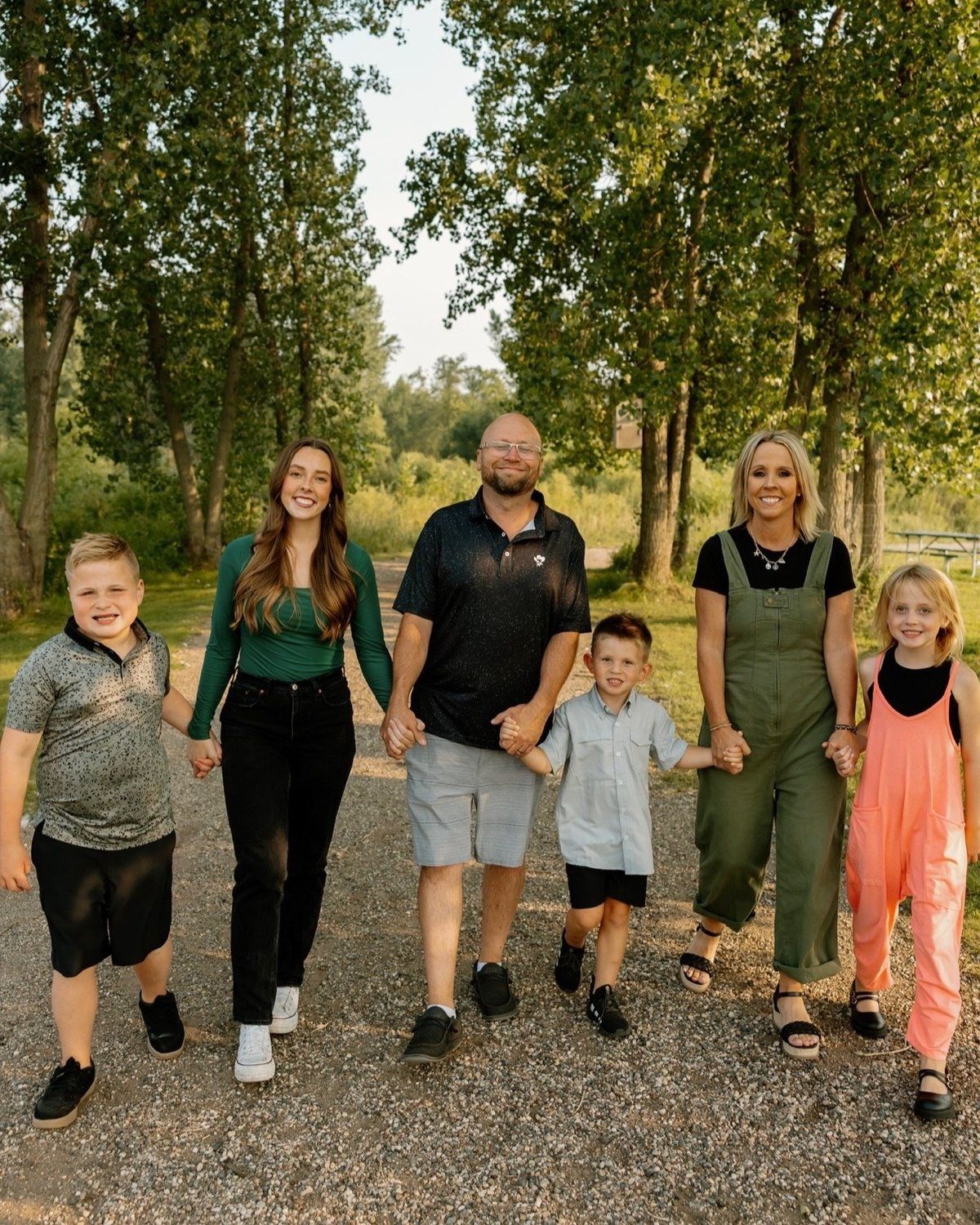Deb Compson and her family walking hand in hand on a tree-lined path