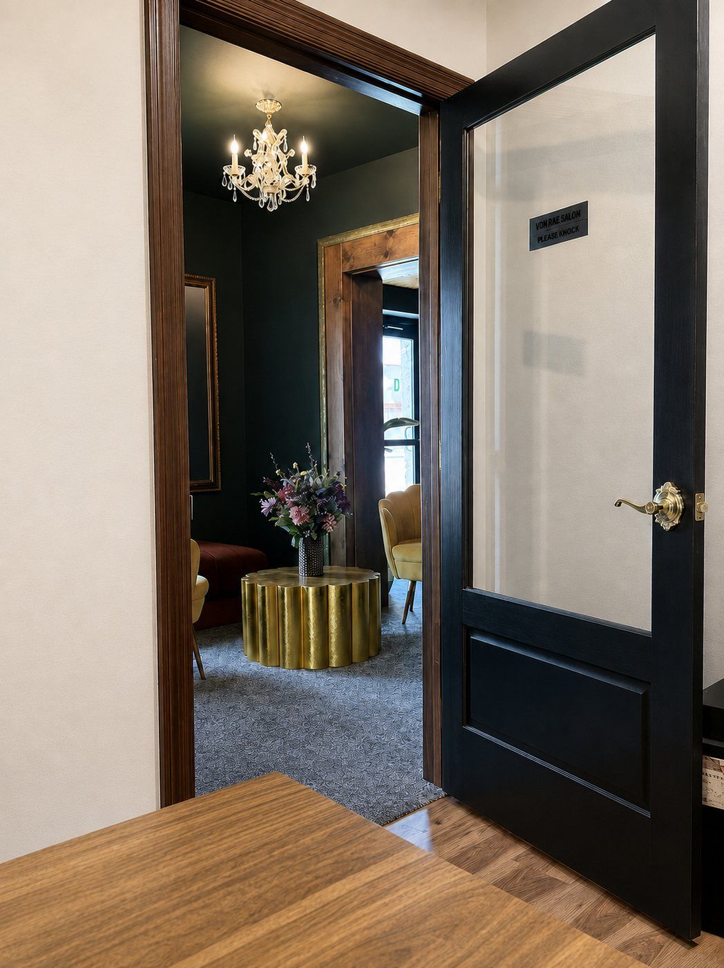 A Von Rae suite doorway with the salon's Please Knock sign, looking into a styled sitting room